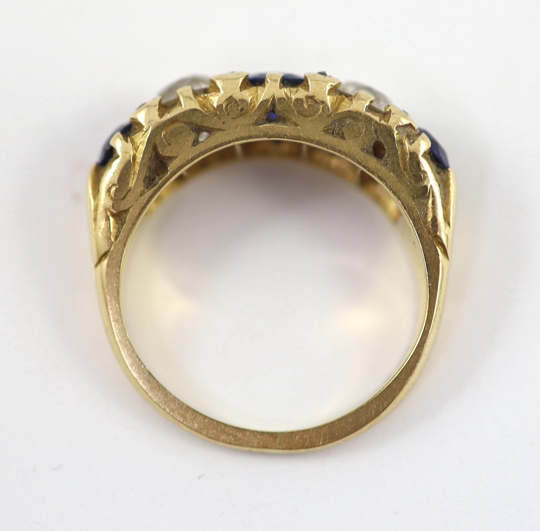 An early 20th century 18ct gold, three stone sapphire and two stone diamond set half hoop ring